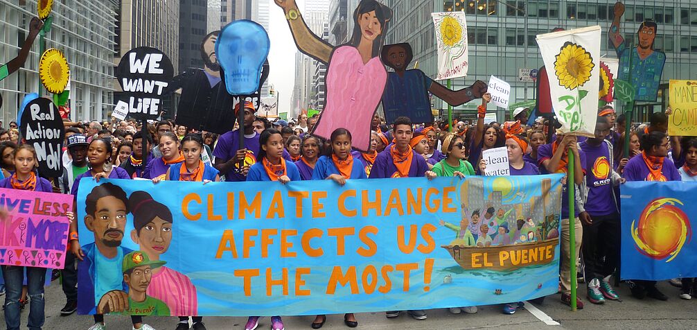 urban protest with banner "climate change affects us the most"